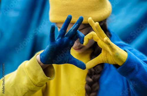 hands of a frightened girl in the shape of a heart are painted in yellow and blue of the Ukrainian flag. Russia's invasion of Ukraine, a request for help to the world community. Children ask for peace