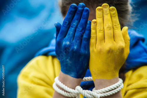 the hands of a frightened girl are painted in the yellow and blue color of the Ukrainian flag. Russia's invasion of Ukraine, a request for help to the world community. Children ask for peace. Stop war