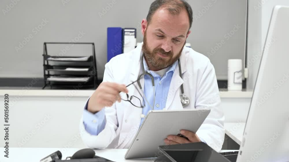 Thoughtful male doctor using digital tablet thinking of medical problem solution. High quality 4k footage Thoughtful male doctor using digital tablet thinking of medical problem solution. High quality 4k footage