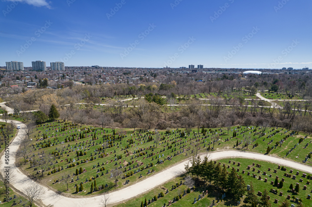 Aerial top very high view of modern cemetery at the city. Small headstones and crosses at graveyard with gravestones.