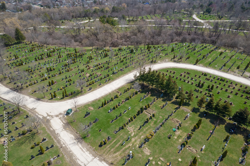 Aerial top very high view of modern cemetery at the city. Small headstones and crosses at graveyard with gravestones.