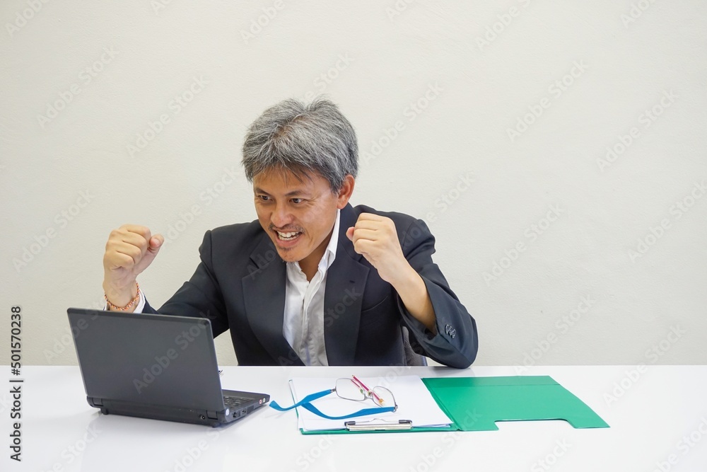 Businessman making a happy gesture looking at the result from the computer Businessman making a happy gesture looking at the result from the computer