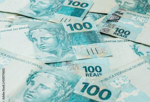 A groud of hundred brazilian real bills spread