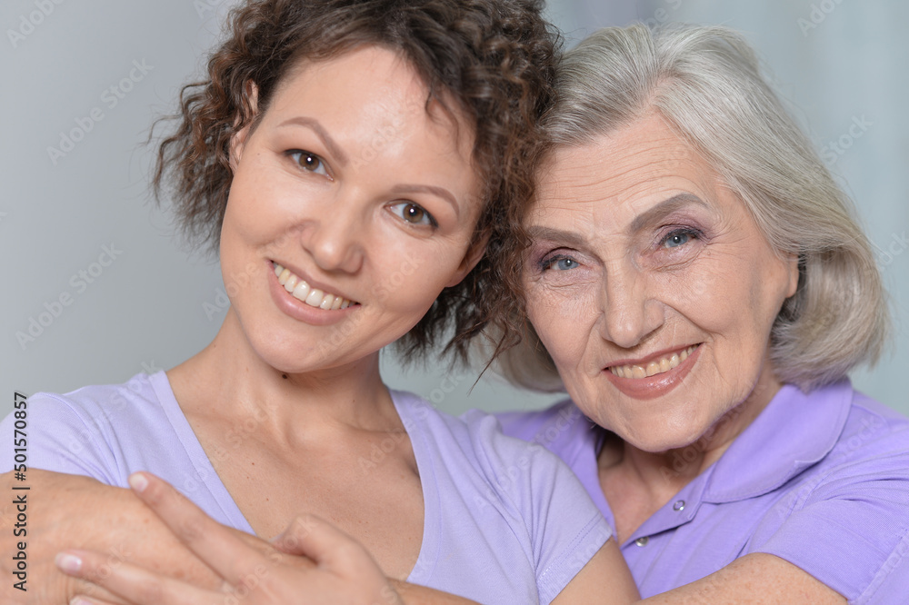 Mature woman embracing with adult daughter at home Mature woman embracing with adult daughter at home