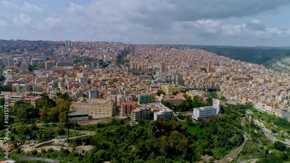 Aerial view showing cityscape of Ragusa on Sicily Island during cloudy day with sun - Beautiful old italian town with park in foreground Aerial view showing cityscape of Ragusa on Sicily Island during cloudy day with sun - Beautiful old italian town with park in foreground