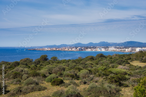 Teleaufnahme von Sa Coma, Mallorca, mit einem Gebirge im Hintergrund und dem Meer und dem Naturschutzgebiet im Vordergrund