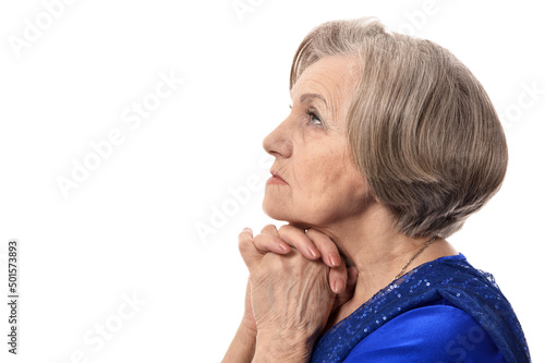 Happy elder woman in elegant dress praying isolated