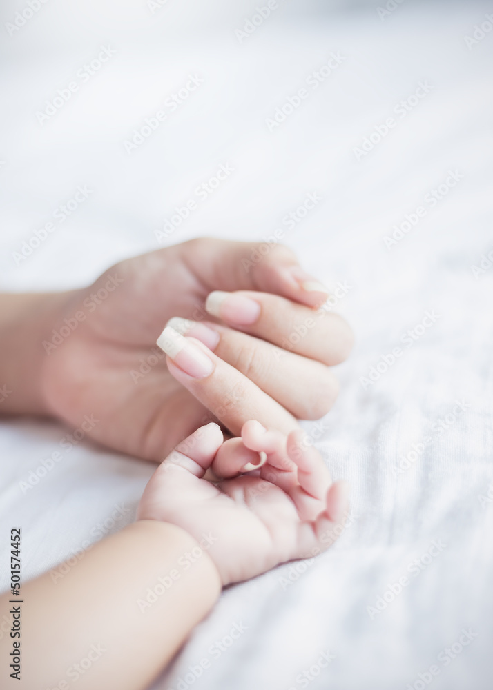 Asian parent hands holding newborn baby fingers, Close up mother’s hand holding their new born baby. Love family healthcare and medical mother’s day concept