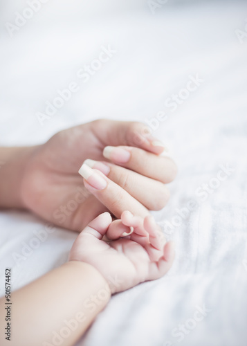 Asian parent hands holding newborn baby fingers, Close up mother’s hand holding their new born baby. Love family healthcare and medical mother’s day concept