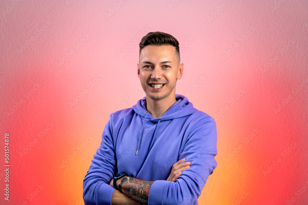 Smiling young good looking man standing against red gradient background Smiling young good looking man standing against red gradient background