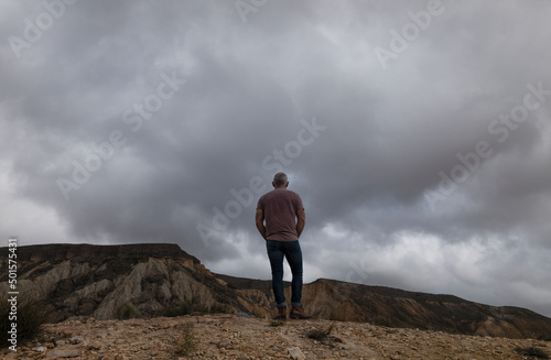 Rear view of adult man on oasis of desert against mountain and sky. Almeria  Spain