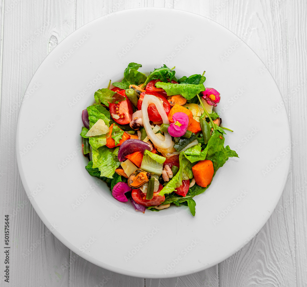 Salad with seafood and fresh vegetables. Healthy salad plate.