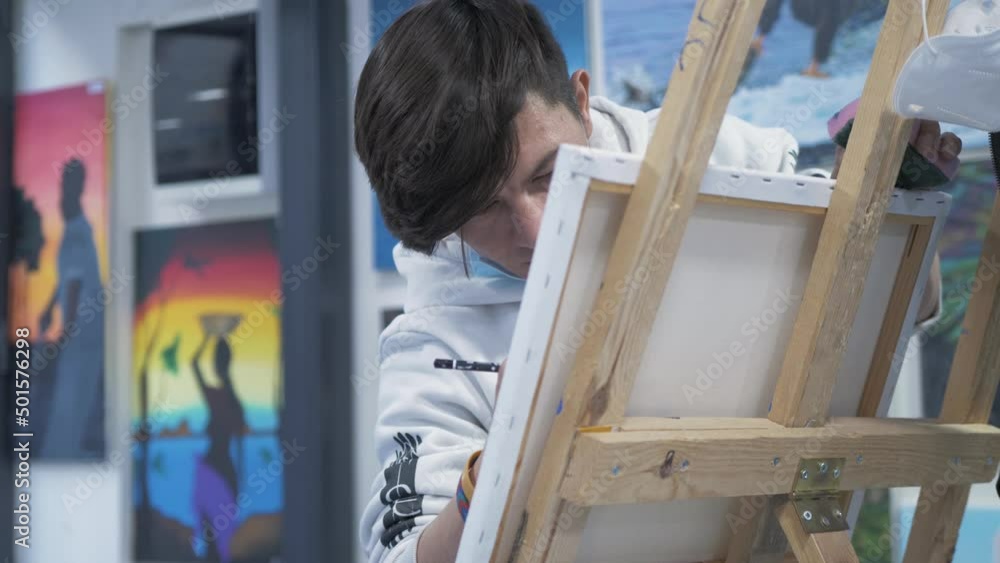 Young talented Afghan painter working in art studio Young talented Afghan painter working in art studio