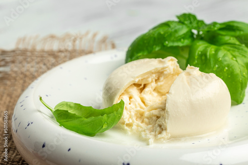 fresh soft white burrata cheese ball made from mozzarella and cream from Apulia, Italian Mediterranean cuisine, Food recipe background. Close up