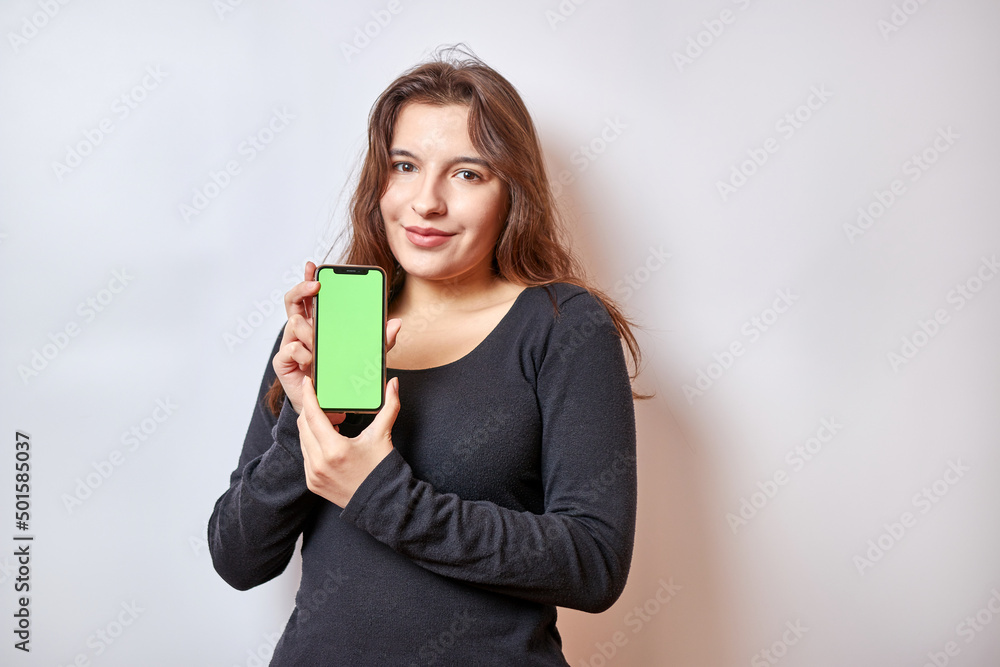 Pretty girl holding a smartphone with a green display. Pretty girl holding a smartphone with a green display.
