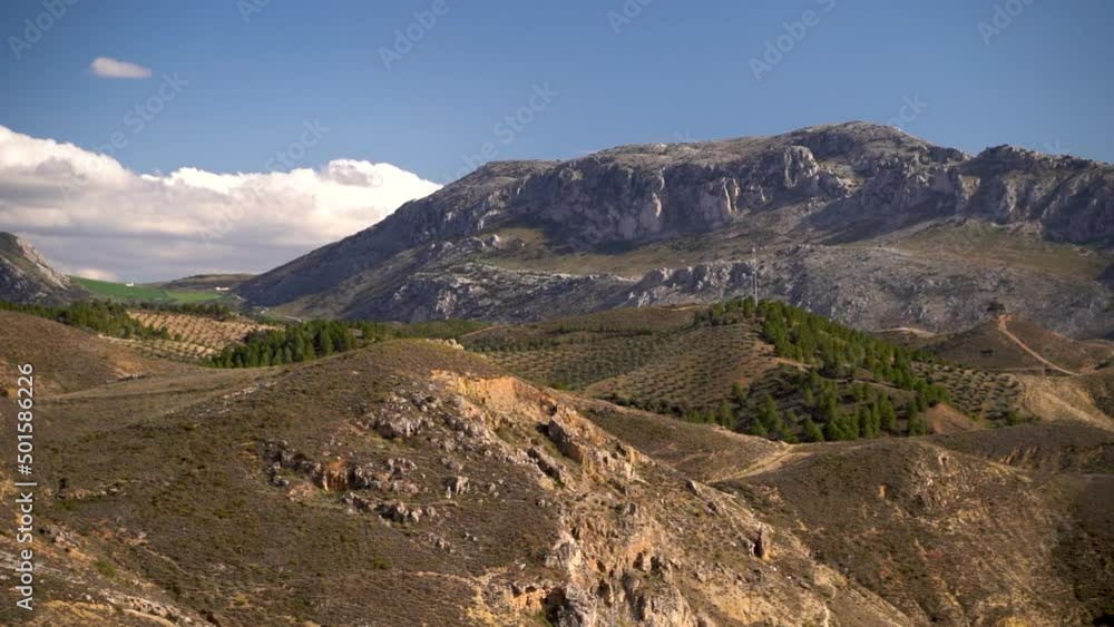 Pan across Mediterranean mountain range with blue sky and clouds