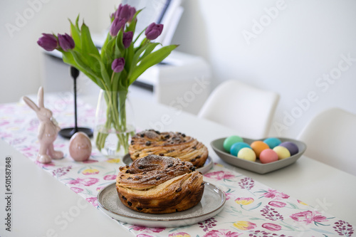 Beautiful spring table with paska or kulich, tulip and colorful easter eggs photo