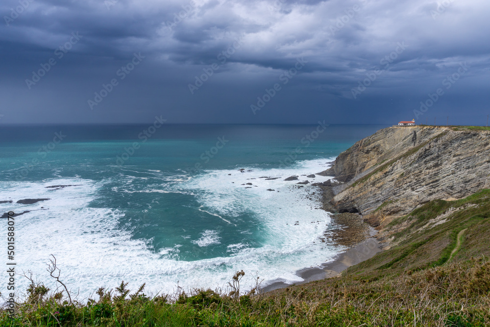 view of the lighthouse on the cliffs at Cabo Vidio under an overcast and stormy sky