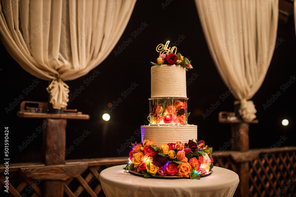 three tiered wedding cake of multicolored roses, wedding day