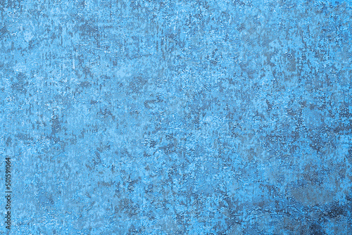 Textured blue background with protrusions and dents, a surface of lines and spots
