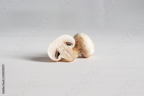 Sliced champignon mushrooms on a gray background