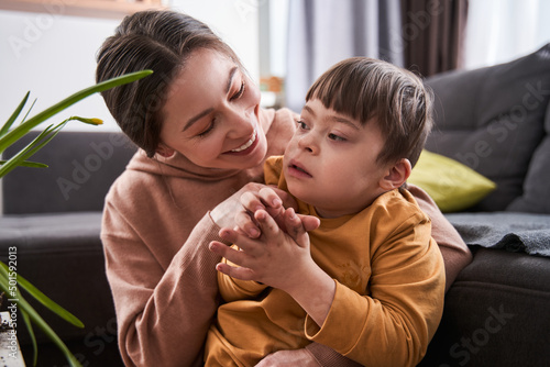 Fotografi Caucasian woman bonding to her son with genetic disorder while sitting near the