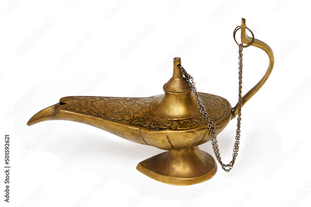 An old yellow metal magic lamp isolated on a white background. An old yellow metal magic lamp isolated on a white background.