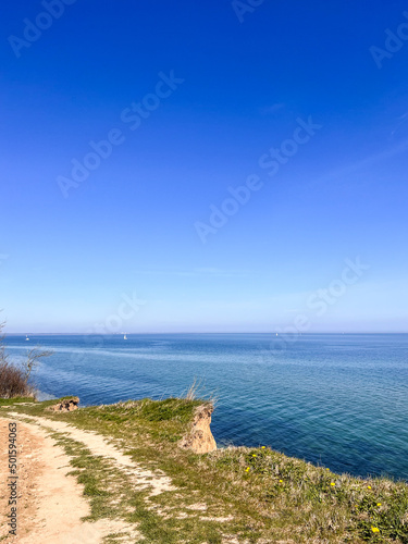 Landscape of blue Baltic sea with white sand and cloudy sky