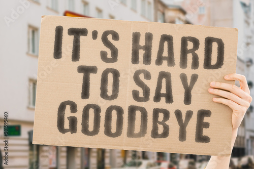 The phrase " It's hard to say goodbye " is on a banner in men's hands with blurred background. Reliability. Important. Relation. Failure. Afraid. Maintenance. Fatherhood. Emotions. Sadness. Protect