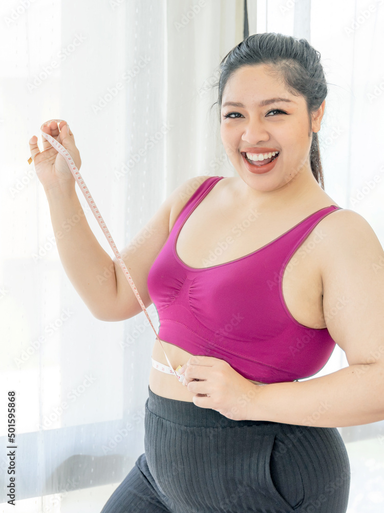 asian fat women , Fat girl , Chubby, overweight measuring her waist in the bedroom - Woman diet lifestyle overweight problem concept