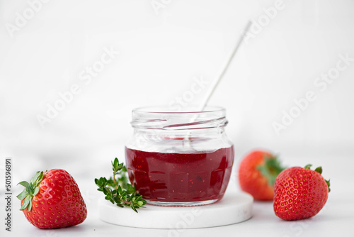 homemade strawberry jam and fresh strawberries on a white table