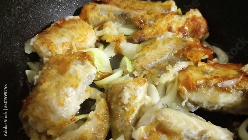 Fish is fried in a pan with onions. The concept of fast and tasty food. High quality video photo