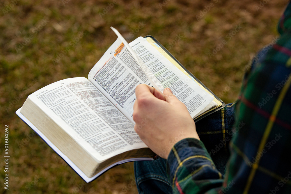 Naklejka premium Flipping pages in the Bible