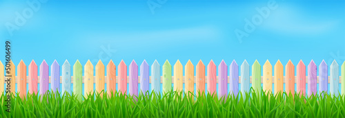 Wooden picket fence on backyard, park or playground. Vector realistic summer or spring landscape with barrier from rainbow colored boards, green grass and clouds in blue sky. Lawn, meadow or field