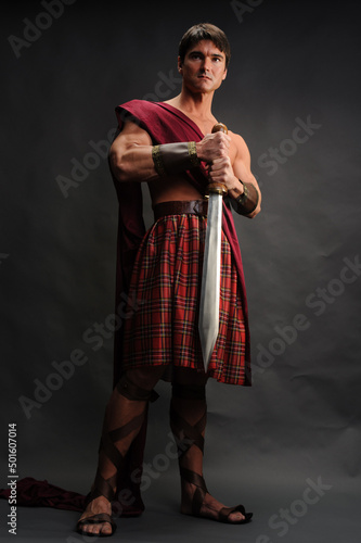 The handsome knight poses for the photo with a highlander costume on.