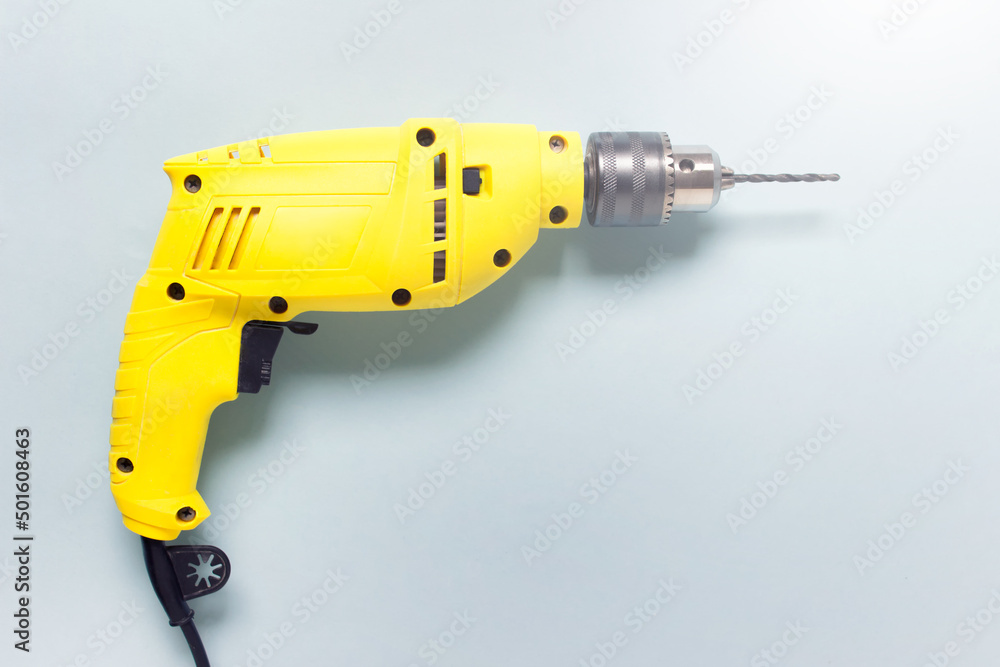 Home renovation yellow drill on blue background. Image with copy blank space Home renovation yellow drill on blue background. Image with copy blank space