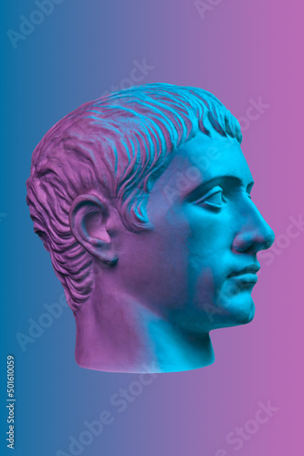 Blue purple gypsum copy of ancient statue of Germanicus Julius Caesar head for artists isolated on color background. Renaissance epoch. Plaster sculpture of man face. Template for art design