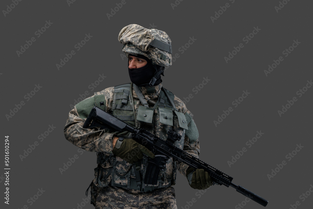 Studio shot of isolated on gray background soldier dressed in camouflage clothes.