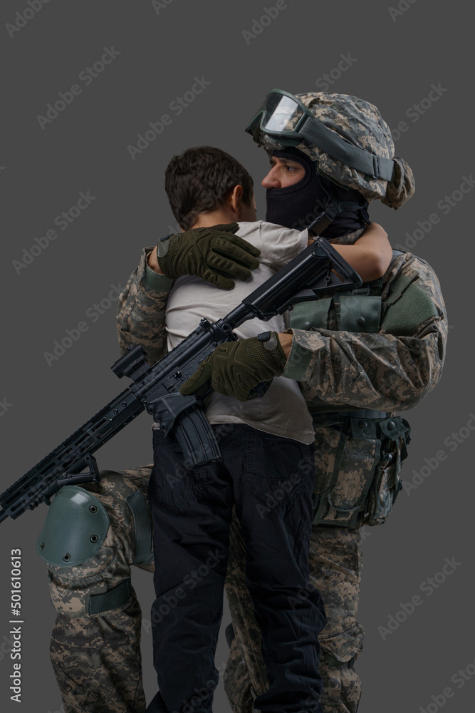 Portrait of professional serviceman dressed in camouflage clothes hugging little boy. Portrait of professional serviceman dressed in camouflage clothes hugging little boy.