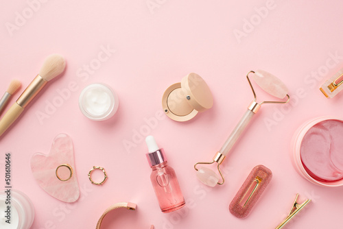 Top view photo of makeup brushes rose quartz roller gua sha pink eye patches gla Fototapeta