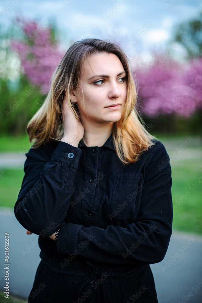 young brunette woman in park with cherry blossoms young brunette woman in park with cherry blossoms
