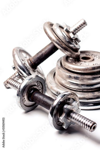 old dumbbells and discs for dumbbells on a white background