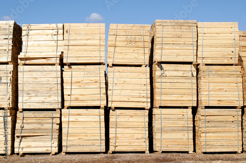 Rough pine lumber stacked at the sawmill. Woodworking plant and sawn timber in stacks for shipment for export. Wooden boards  lumber  commercial timber. Pine timber.