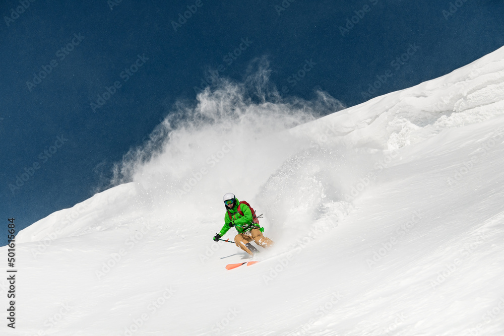 Young man skier running down the slope in the Carpathian mountains.