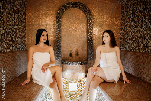 Beauty, spa, healthy lifestyle concept. Beautiful young girls relaxing at luxury turkish spa with hammam sauna photo