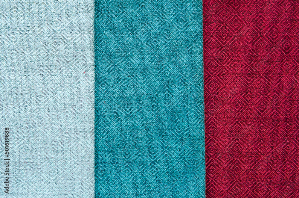 Fototapeta premium Grey, blue, red background. set of multi-colored dense fabrics of uniform texture. choice of materials in different colors. vertical fragments.