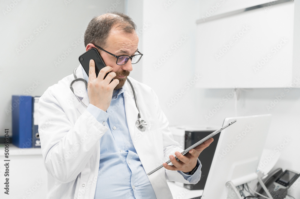 Doctor in office talking on phone. High quality photography. Doctor in office talking on phone. High quality photography.