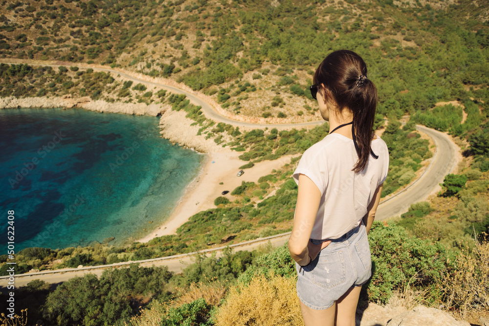 Woman looking on coastline of Datca with small beach deep and crystal blue cove. Aegean coast of Datca peninsula, Turkey Woman looking on coastline of Datca with small beach deep and crystal blue cove. Aegean coast of Datca peninsula, Turkey