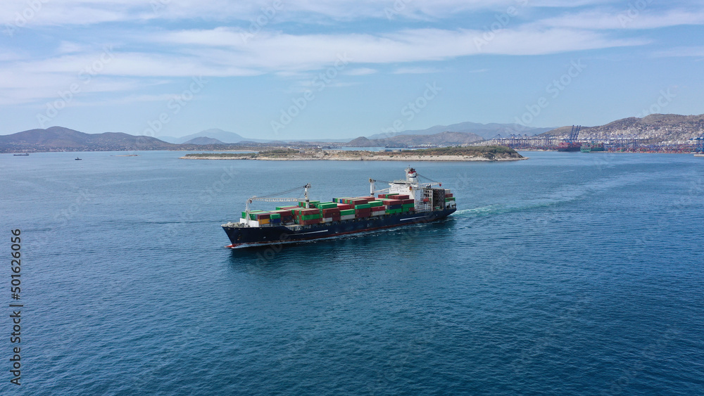 Aerial drone photo of container ship leaving logistics and container terminal of Perama, Attica, Greece