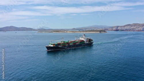 Aerial drone photo of container ship leaving logistics and container terminal of Perama, Attica, Greece